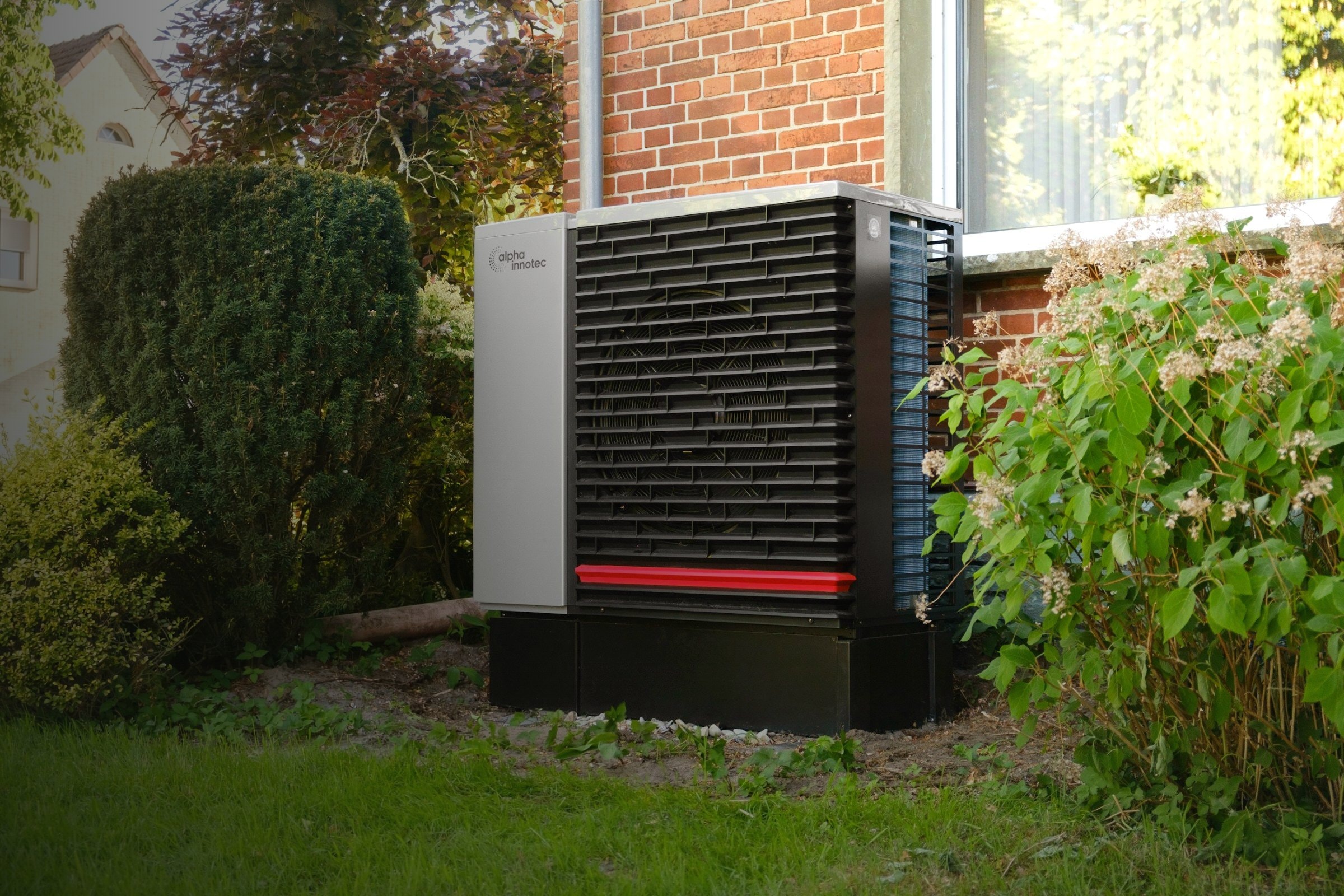 Wärmepumpe neben einem Klinkerhaus