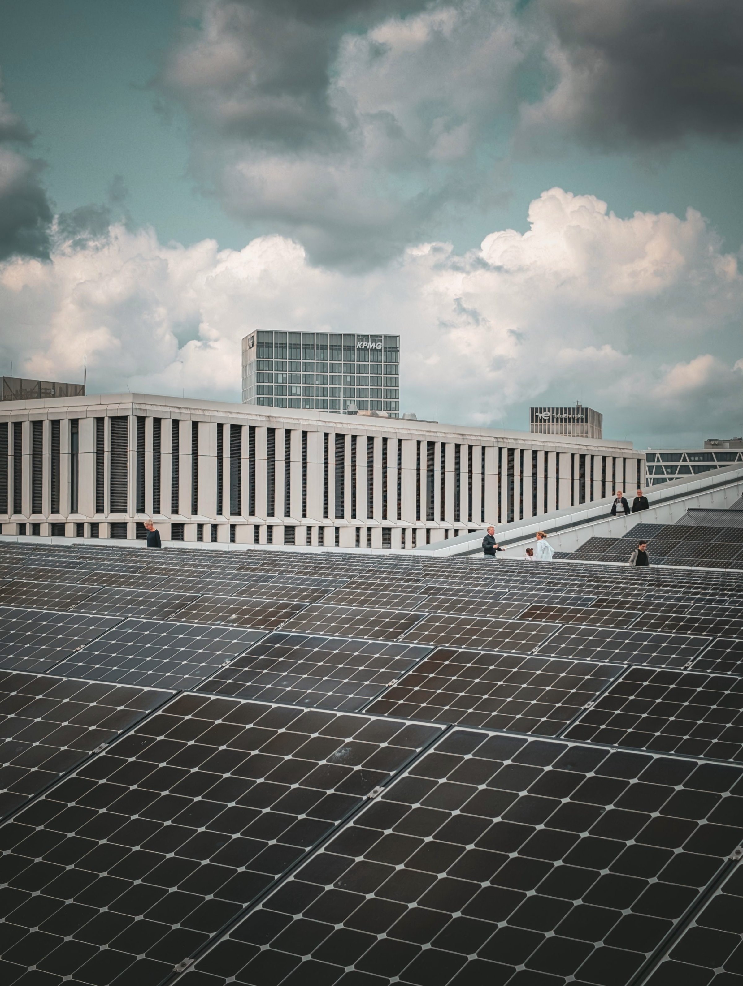Großes Flachdach mit schwarzen Solarmodulen vor einem Bürogebäude