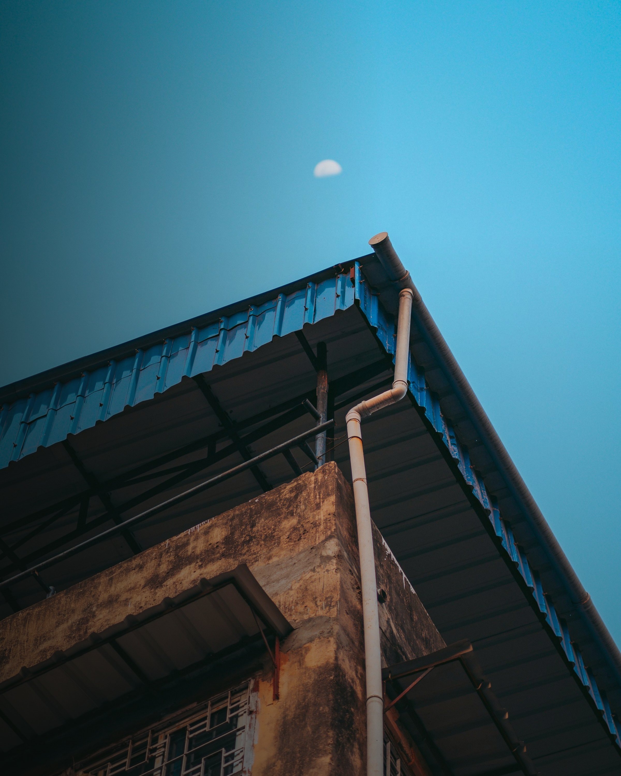 Klinkergebäude mit Dachrinne vor blauem Himmel