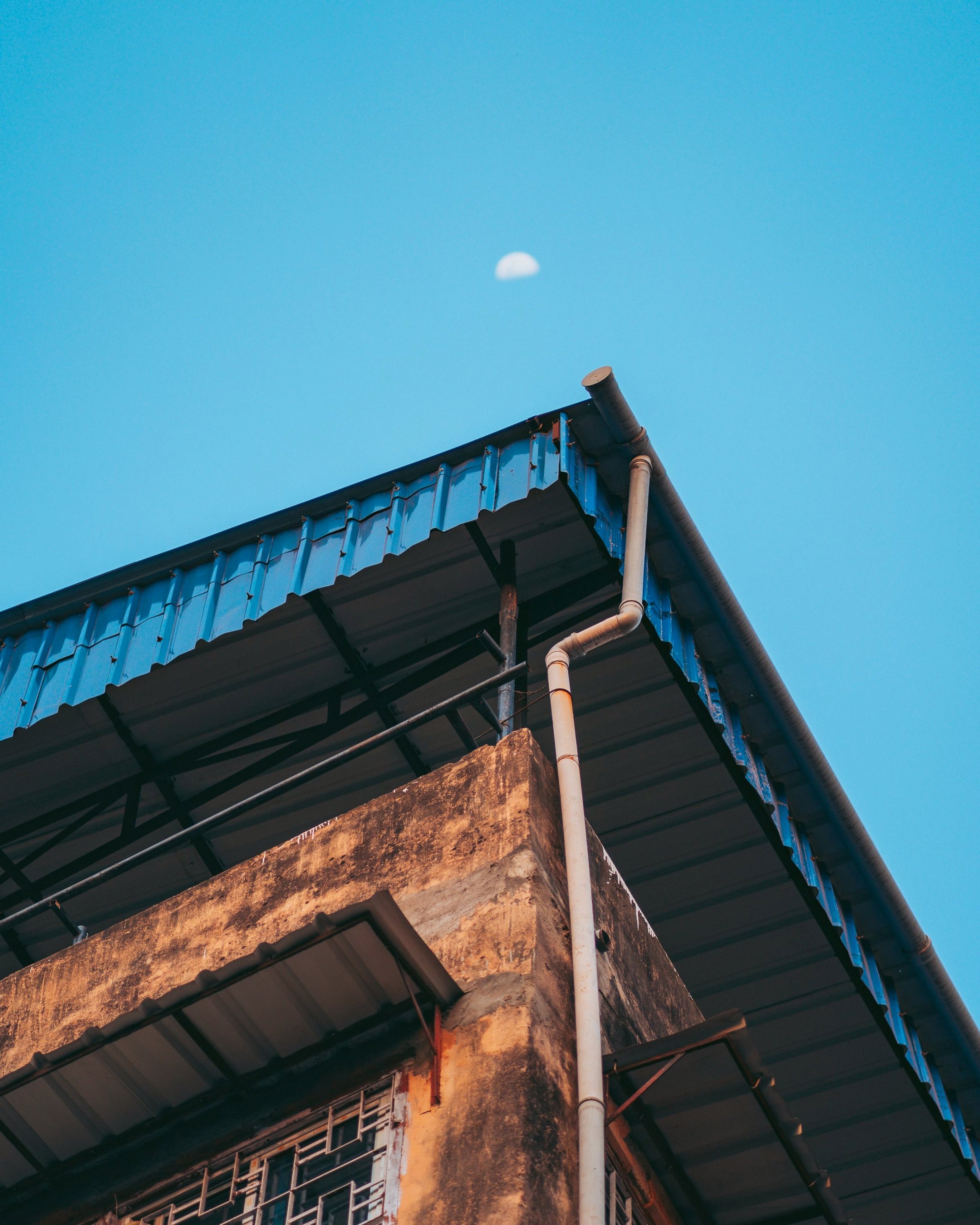 Klinkergebäude mit Dachrinne vor blauem Himmel