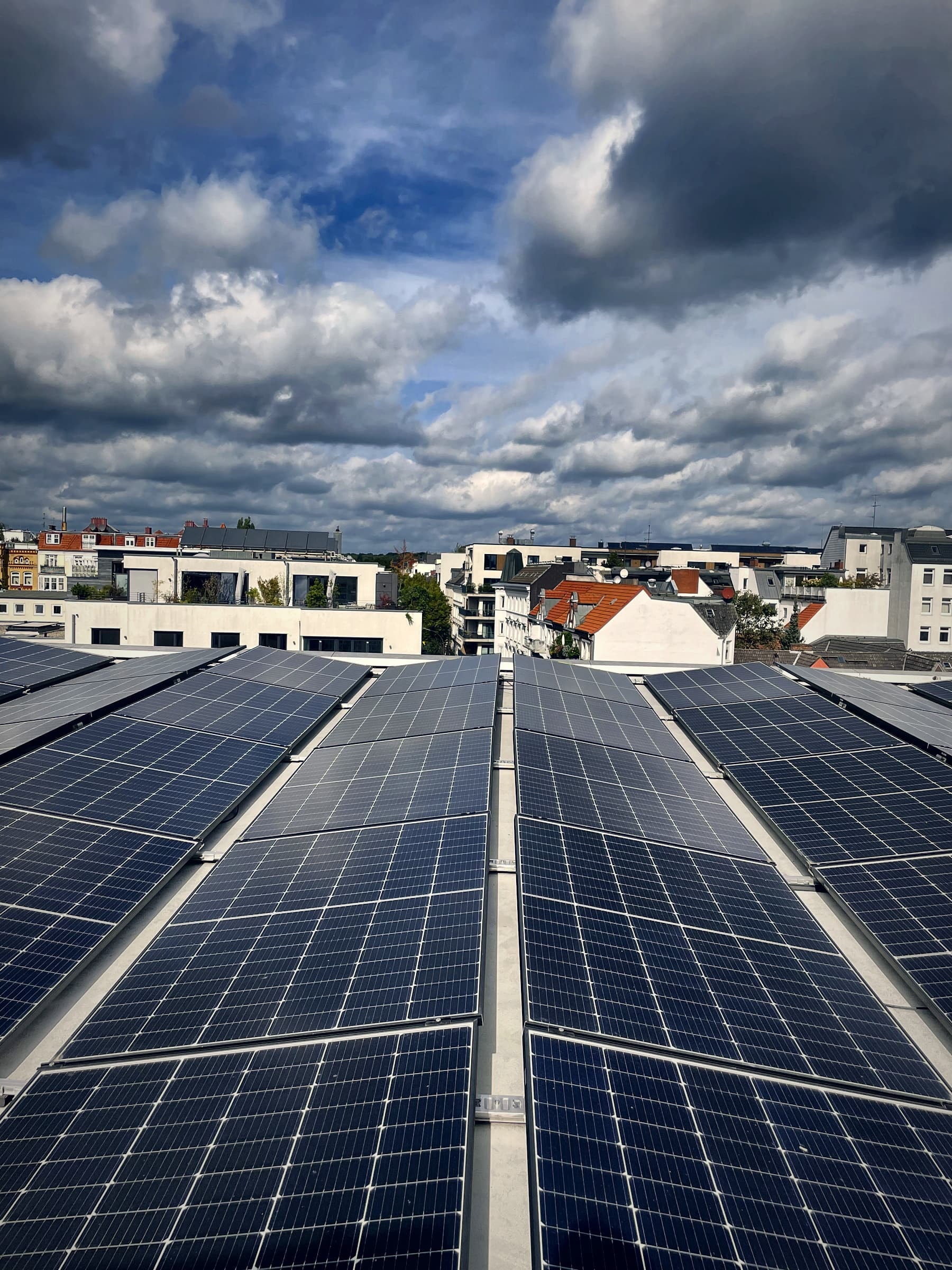 Photovoltaikanlage mit Solarmodulen auf Flachdach über einer Stadt zur Stromerzeugung