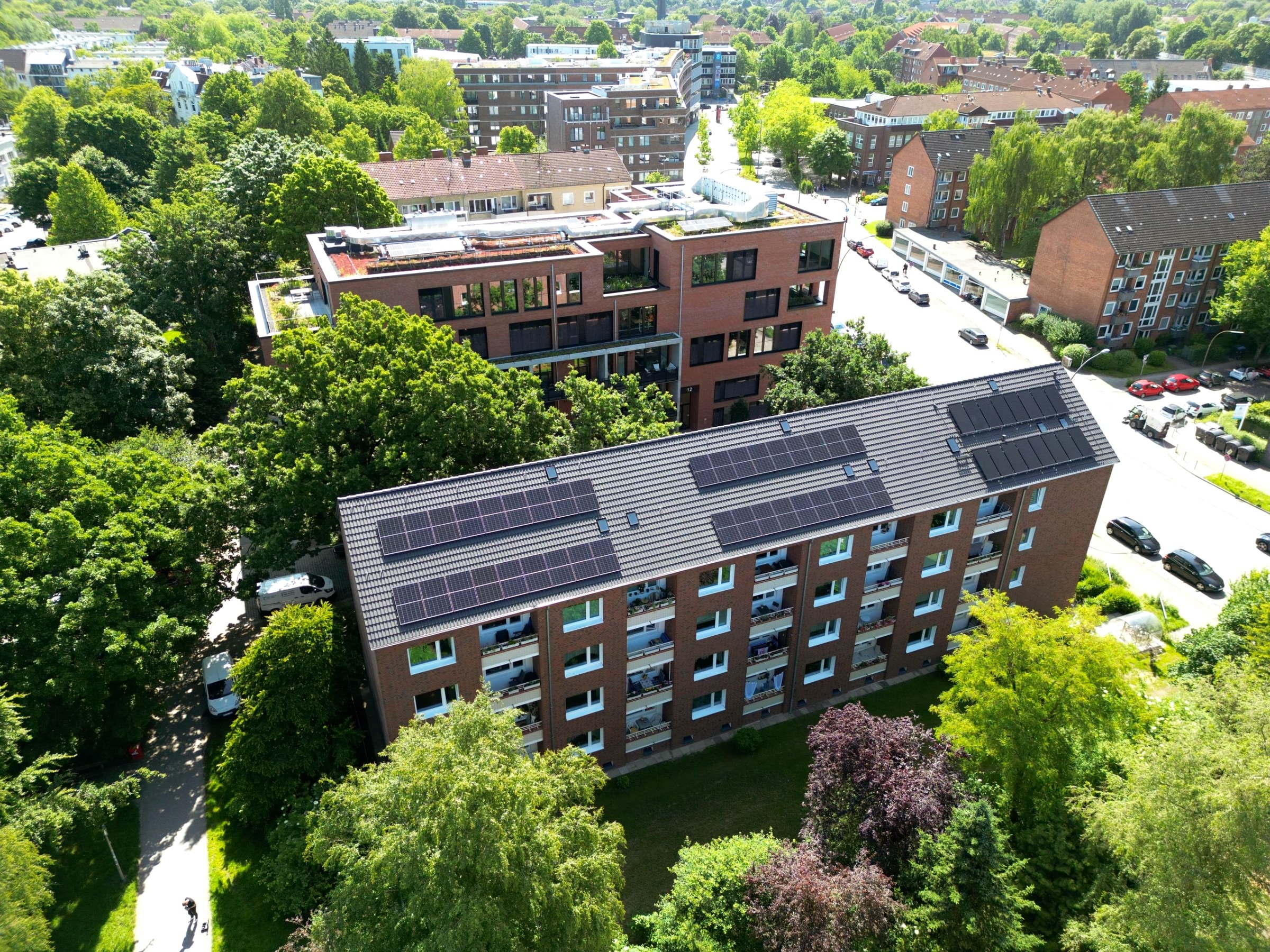 Luftaufnahme eines Mehrfamilienhauses mit Photovoltaikanlage auf dem Dach in der Stadt