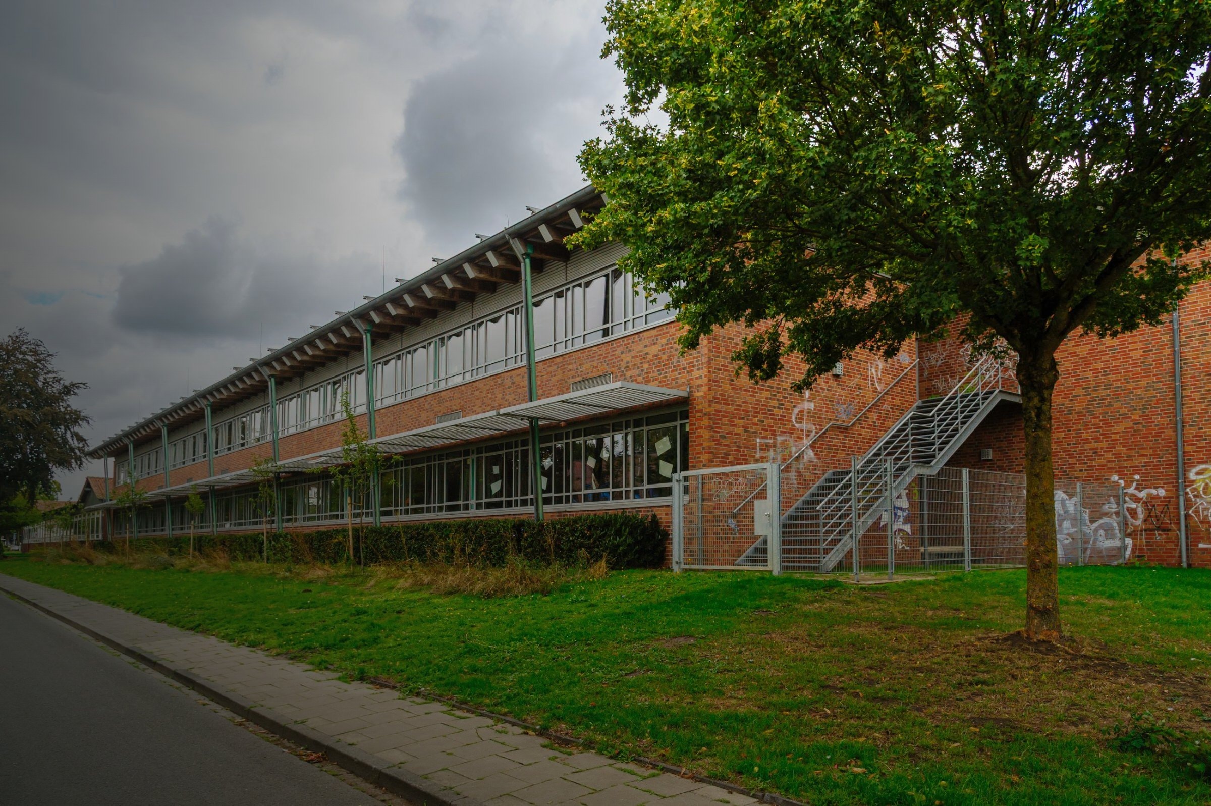 Schulgebäude aus Backstein mit Rasenfläche